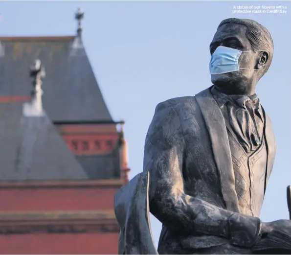  ??  ?? A statue of Ivor Novello with a protective mask in Cardiff Bay
