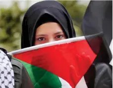  ??  ?? امرأة تحمل علم فلسطين خلال احتجاج على الذكرى المئوية لإعلان بلفور، قرب سفارة بريطانيا في بيروت، أمس. )أ.ف.ب(