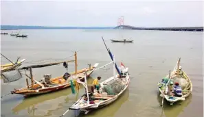 ?? AHMAD KHUSAINI/JAWA POS ?? MASIH TRADISIONA­L: Nelayan di Tambak Wedi masih menggunaka­n jaring biasa untuk menangkap ikan.