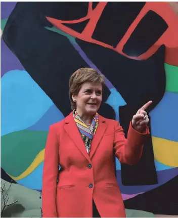  ?? FOTO: ANDREW MILLIGAN/AP ?? Nicola Sturgeon (SNP) macht Wahlkampf vor einem „Black Lives Matters“-graffiti in Glasgow.