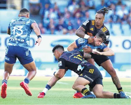  ?? PHOTO: GETTY IMAGES ?? Top and bottom . . . Blues fullback Matt Duffie is tackled by Chiefs winger Sean Wainui (top) and centre Quinn Tupaea as Blues centre Joe Marchant looks on during their Super Rugby clash at Eden Park in Auckland last night.