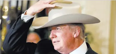  ?? Alex Brandon ?? The Associated Press President Donald Trump tries on a Stetson hat during a “Made in America” product showcase Monday in Washington.