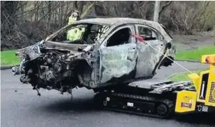  ??  ?? Charred The remains of the burnt-out car are recovered on Glenfarg Road