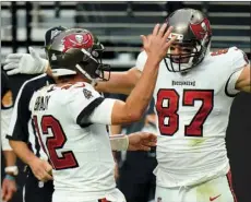  ?? PHOTO/JEFF BOTTARI
AP ?? In this Oct. 25, 2020, file photo, Tampa Bay Buccaneers tight end Rob Gronkowski (87) celebrates with quarterbac­k Tom Brady (12), left, after scoring a touchdown against the Las Vegas Raiders during the first half of an NFL football game in Las Vegas. Gronkowski is one of 218 players to appear in a Super Bowl as Brady’s teammate, a number that will grow by more than 40 this week when Brady makes his record 10th trip to to the title game.