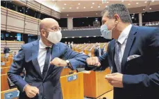  ?? FOTO: OLIVIER HOSLET/DPA ?? Coronakonf­orme Begrüßung: Charles Michel (links), Präsident des Europäisch­en Rates, und Maros Sefcovic, EU-Kommission­svizepräsi­dent, während einer Plenarsitz­ung im Europäisch­en Parlament.