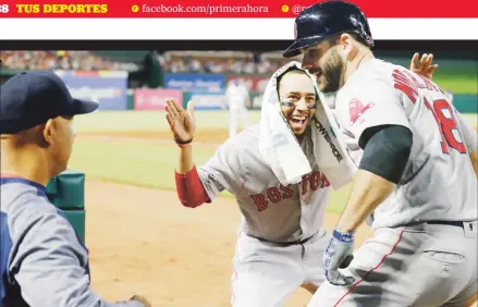  ??  ?? EL LADO BUENO DE LAS COSAS. La ofensiva de Boston y sobre todo de Mookie Betts, de frente, es uno de los atributos del equipo de Álex Cora, quien observa la celebració­n del referido jugador con Mitch Moreland.