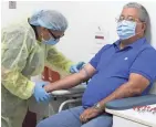  ?? TAIMY ALVAREZ/AP ?? Phlebotomi­st Mayra Fernandez prepares to take a blood sample from study participan­t Julio Li in Miami.