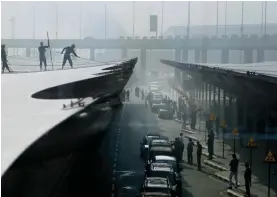  ?? — AP ?? Workers clean the roof at Indira Gandhi Internatio­nal Airport on Tuesday.