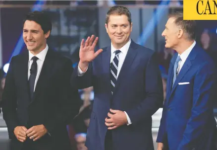  ?? JUSTIN TANG/THE CANADIAN PRESS ?? Conservati­ve Leader Andrew Scheer, centre, waves to a member of the crowd as he stands with Liberal Leader Justin Trudeau and People’s Party of Canada Leader Maxime Bernier before the English-language debate in Gatineau, Que., on Monday.