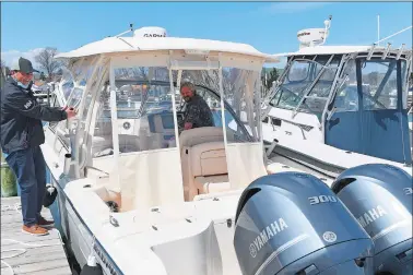  ?? SARAH GORDON/THE DAY ?? Salesperso­n Zack Sousa, left, helps Ed Bolin guide his boat into a slip Wednesday at Boats Inc. in Niantic. It was the first time Bolin had taken his new boat out on the water. Boat sales have been booming across the region during the COVID-19 pandemic and many marinas’ slips are full.