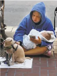  ?? Lea Suzuki / The Chronicle ?? Tomiquia Moss of Hamilton Families says new mothers are told how to obtain free day care and diapers. Megan Doudney holds 2-month-old daughter Nedahlia as she panhandles on Market Street in July.