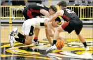  ?? MARK HUMPHREY ENTERPRISE-LEADER ?? Prairie Grove senior Carl Von Bergon (wearing white uniform) struggles against the combined efforts of Pea Ridge’s Greydon Edwards (left) and Hunter Rains to maintain possession of the basketball. Pea Ridge defeated Prairie Grove, 40-28, on the Tigers’ home-court in the District 4-1 boys basketball semifinal Thursday, Feb. 27.