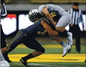  ??  ?? Cal’s Camryn Bynum, left, tackles Oregon’s Travis Dye during the first quarter on Saturday at Memorial Stadium.