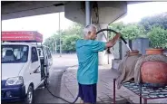  ?? IANS ?? 69-year-old Alagaratha­nam Natarajan refilling the ‘matkas’ installed by him in Delhi.