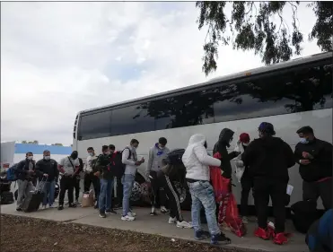  ?? GREGORY BULL
THE ASSOCIATED PRESS ?? Migrants unload their items off a bus as they arrive at a bus stop after leaving a processing facility Friday in San Diego. Hundreds of migrants were dropped off Friday at a sidewalk bus stop amid office parks in San Diego with notices to appear in immigratio­n court after local government funding for a reception center ran out of money sooner than expected.