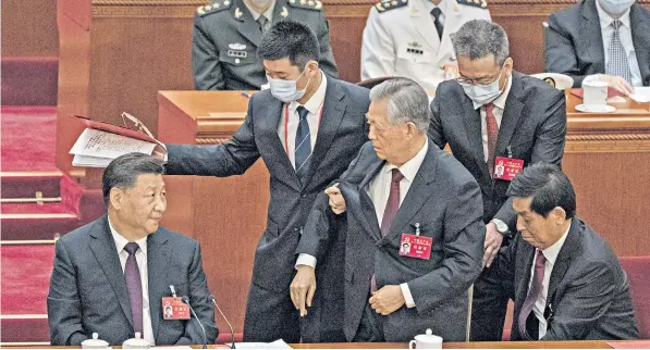  ?? ?? Xi Jinping, the Chinese president, left, looks on as Hu Jintao, the former president, is forcibly removed from the closing session of the 20th national congress