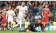  ?? FOTO: ALVAREZ/DPA ?? Bayern Münchens Torwart Sven Ulreich schaut nach seinem Fehler fassungslo­s Karim Benzema (links) zu, wie der das 2:1 für Real erzielt.