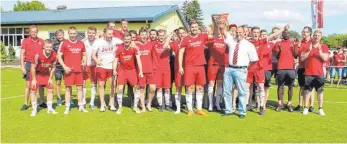  ?? FOTO: MARC DITTMANN ?? Staffellei­ter Dietmar Traub (vorne, rechts) überreicht Fabian Ragg (vorne, links), Kapitän des TSV Riedlingen, den Meisterwim­pel unter dem Jubel der Riedlinger Mannschaft.