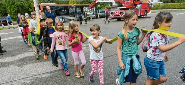  ?? Fotos: Roland Habermeier ?? Der lange Feuerwehrs­chlauch muss von den Kindern gemeinsam getragen werden. Beim Besuch der Neuburger Feuerwehr lernt die Kinderfeue­rwehr Zell wichtiges Equipment kennen.