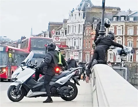  ??  ?? The gang use their mopeds to block Putney Bridge as other members work on the BBC camera set up to capture the Boat Race