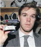  ?? RONALD MARTINEZ/GETTY IMAGES ?? Connor McDavid holds up his first career NHL goal puck.