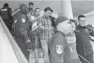  ?? — Gambnar Bernama ?? DITAHAN: Anggota polis membawa sebahagian daripada 20 anggota Geng Pak Su di Mahkamah Sesyen dekat Alor Setar, semalam kerana terbabit dalam aktiviti penyeludup­an di sekitar sempadan Malaysia-Thailand.