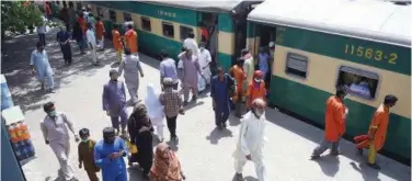  ?? Agence France-presse ?? ↑ Passengers walk on a railway station in Karachi on Wednesday.