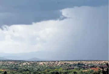  ?? LUIS SÁNCHEZ SATURNO/THE NEW MEXICAN ?? The Jemez Mountains are concealed Monday behind a monsoon rain shower. The monsoons got off to a late start in New Mexico, but the state could see one of its wettest Augusts in years, meteorolog­ists with the National Weather Service said Monday.