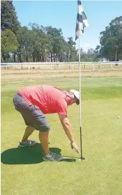  ?? ?? Matthew Guy retrieves his lucky golf ball after making two on a par five hole.