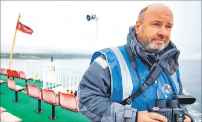  ??  ?? Wildlife officer Andy Gilbert on the lookout for marine life in the Minch.