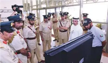  ?? Courtesy: Dubai Police ?? Maj-Gen Abdullah Khalifa Al Merri and other senior Dubai Police officials during a demonstrat­ion of the drone’s live broadcast capabiliti­es yesterday.