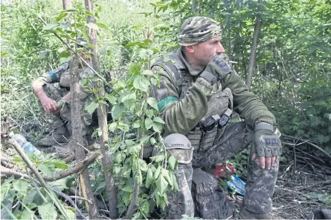  ?? ?? Ukrainian servicemen rest at the side of a road leading towards the Ocheretyne area in the Donetsk region on Sunday, amid the Russian invasion of Ukraine.