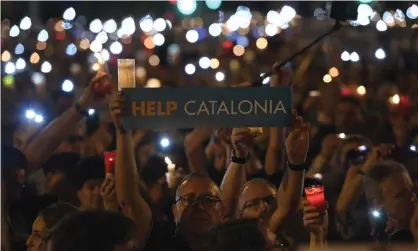  ??  ?? A man holds a placard during candle-lit demonstrat­ion in Barcelona against the arrest of two Catalan separatist leaders. Photograph: Lluis Gene/AFP