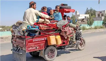  ?? (AFP) ?? Internally displaced people flee with their belongings from Nadali district to Lashkar Gah during the ongoing clashes between Taliban fighters and Afghan security forces, in Helmand province on Wednesday