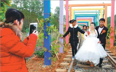  ?? PHOTOS BY HUO YAN / CHINA DAILY ?? A 7-kilometer rail
in Heshan has become a magnet for local people for their wedding photos.