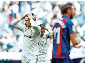  ?? FOTO: DE LA FUENTE/SHOT FOR PR/DPA ?? Gareth Bale (links) kann es nicht fassen. Im Hintergrun­d greift sich auch Real-Kapitän Sergio Ramos an den Kopf. Nach der Niederlage gegen UD Levante brennt bei Real Madrid der Baum.