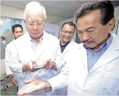  ??  ?? Najib capturing for posterity the first ever successful­ly bred spiny lobsters in captivity on Musa’s palm with Dr. Shahridan looking on (middle).