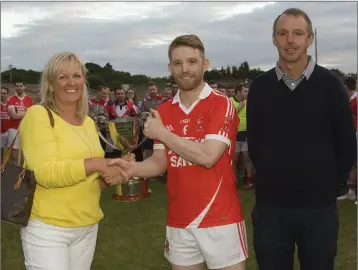  ??  ?? Catherine Finan presenting the Gerry Finan Cup to Tinahely captain Raymond McGlynn, with County Chairman Martin Fitzgerald.