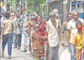  ?? SAMIR JANA /HT PHOTO ?? People wait to collect food at College Street in Kolkata on Monday.