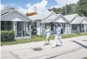  ?? ?? Fabio Riberio walks with real estate agent Kathrin Rein near the historic homes he bought and plans to renovate.