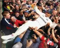  ?? CLIVE MASON, GETTY IMAGES ?? Race winner Lewis Hamilton celebrates with the fans after the British Grand Prix at Silverston­e on Sunday.