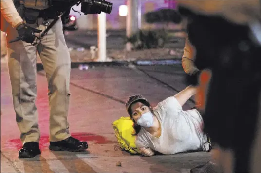  ?? Ellen Schmidt Las Vegas Review-Journal ?? Photojourn­alist Bridget Bennett is arrested by Las Vegas officers while covering a protest Friday near the Strip. She faced a misdemeano­r charge of failure to disperse.