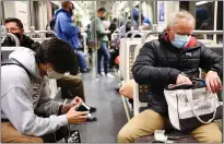  ?? Mario Tama
/ Getty Images /TNS ?? People wear face coverings while riding a Los Angeles Metro Rail train on Dec. 15 in Los Angeles.