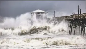  ?? Travis Long / Associated Press ?? Waves slam the Oceana Pier &amp; Pier House Restaurant in Atlantic Beach, N.C., on Thursday as Hurricane Florence approaches the area.