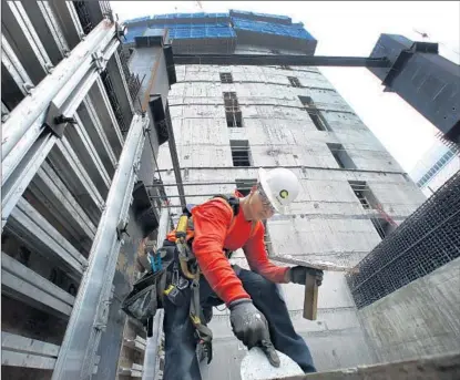  ?? Mel Melcon Los Angeles Times ?? JUDGING FROM most major indicators including building permits, California’s economy is moving at one of the fastest clips of any state over the last few years. Above, carpenter Angel Diaz works on the Wilshire Grand Center last year in L.A.