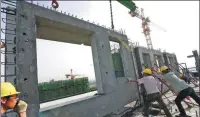  ?? ZHANG TAO / FOR CHINA DAILY ?? Constructi­on workers install thermal-insulating walls at a property project in Zhengzhou, capital of Henan province.