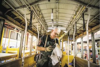  ?? Gabrielle Lurie / The Chronicle ?? Carpenter John Barberini works on a cable car at the Muni repair shop in S.F.’s Dogpatch neighborho­od.