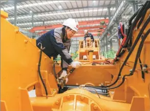  ?? LIU CHANGSONG / FOR CHINA DAILY ?? An employee works on the production line of a heavy machinery manufactur­ing firm in Suining, Sichuan province.