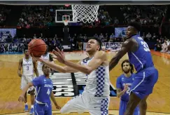  ?? Associated Press ?? ■ Kentucky forward Kevin Knox, center, gets around Buffalo forward Nick Perkins, right, for a shot during the second half of a second-round game in the NCAA men’s college basketball tournament Saturday in Boise, Idaho.