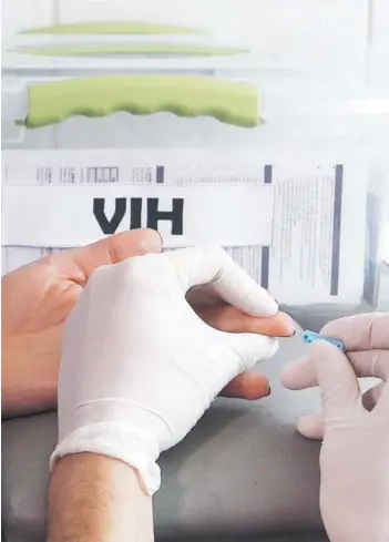  ??  ?? ► Profesiona­l de la salud toma muestra de sangre para examen de VIH/sida.